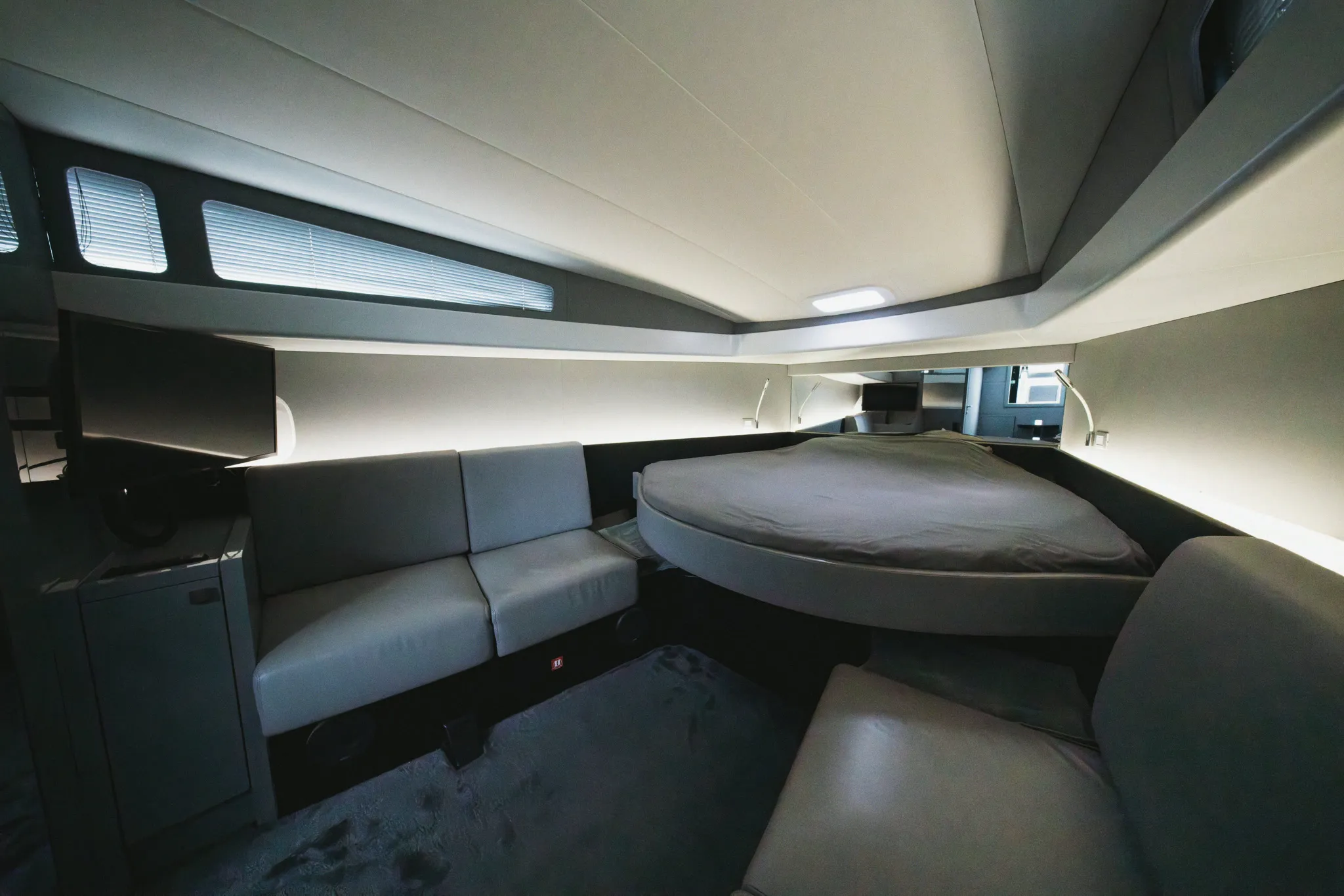 La cabine double : couchage rond, banquette d'angle et rangements.