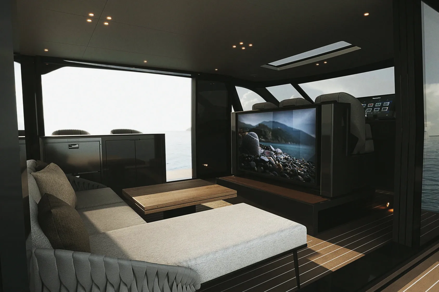 Le lounge intérieur : banquette, téléviseur et baies ouvertes sur la mer.