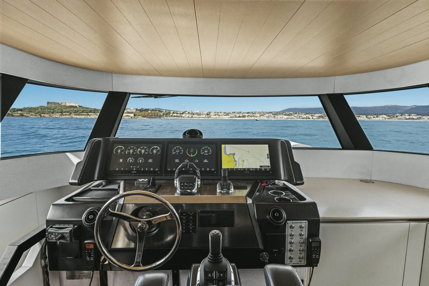 Le poste de pilotage intérieur : barre, écrans et pare-brise panoramique.