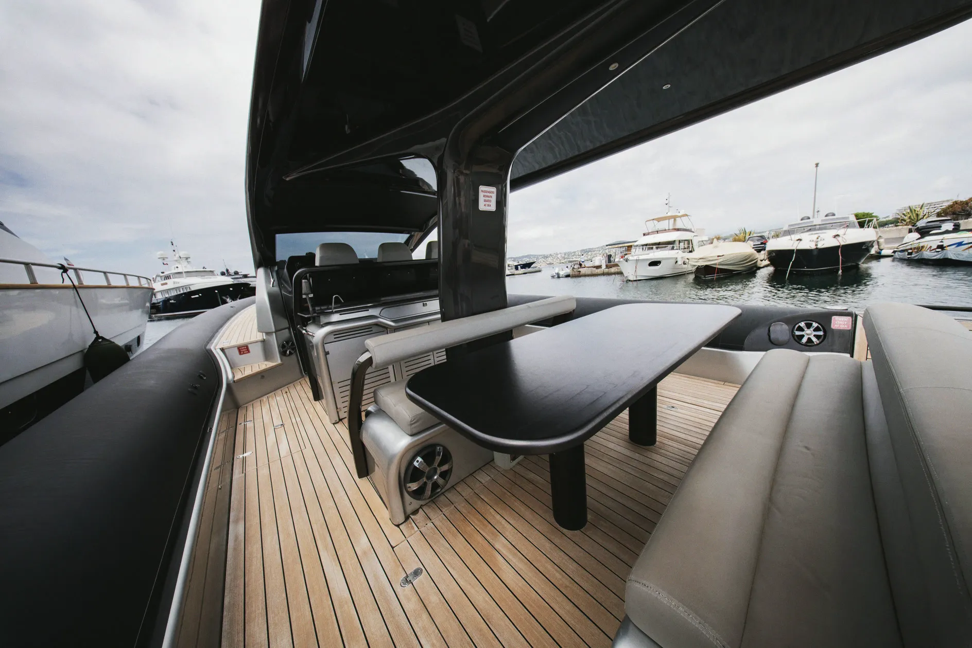 Le cockpit sous le hardtop : table centrale, assises et pont en teck.