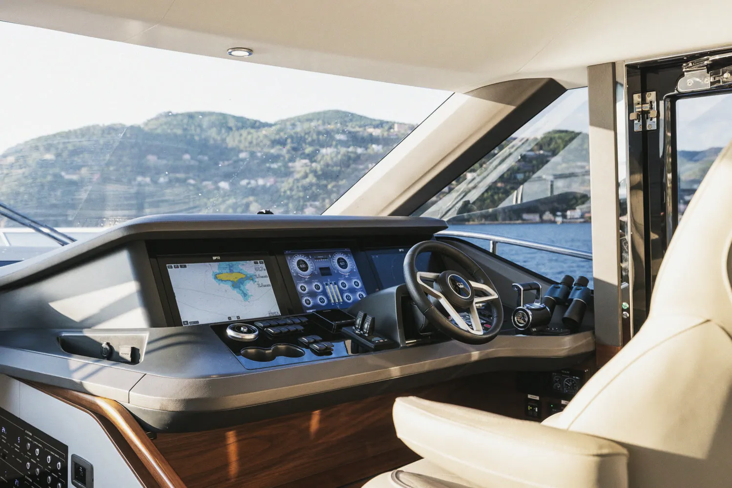 Le poste de pilotage intérieur : barre, écrans et sièges en cuir clair.