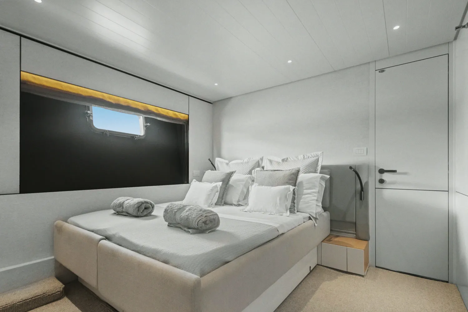 Une cabine invités : couchage double, linge blanc et hublot.
