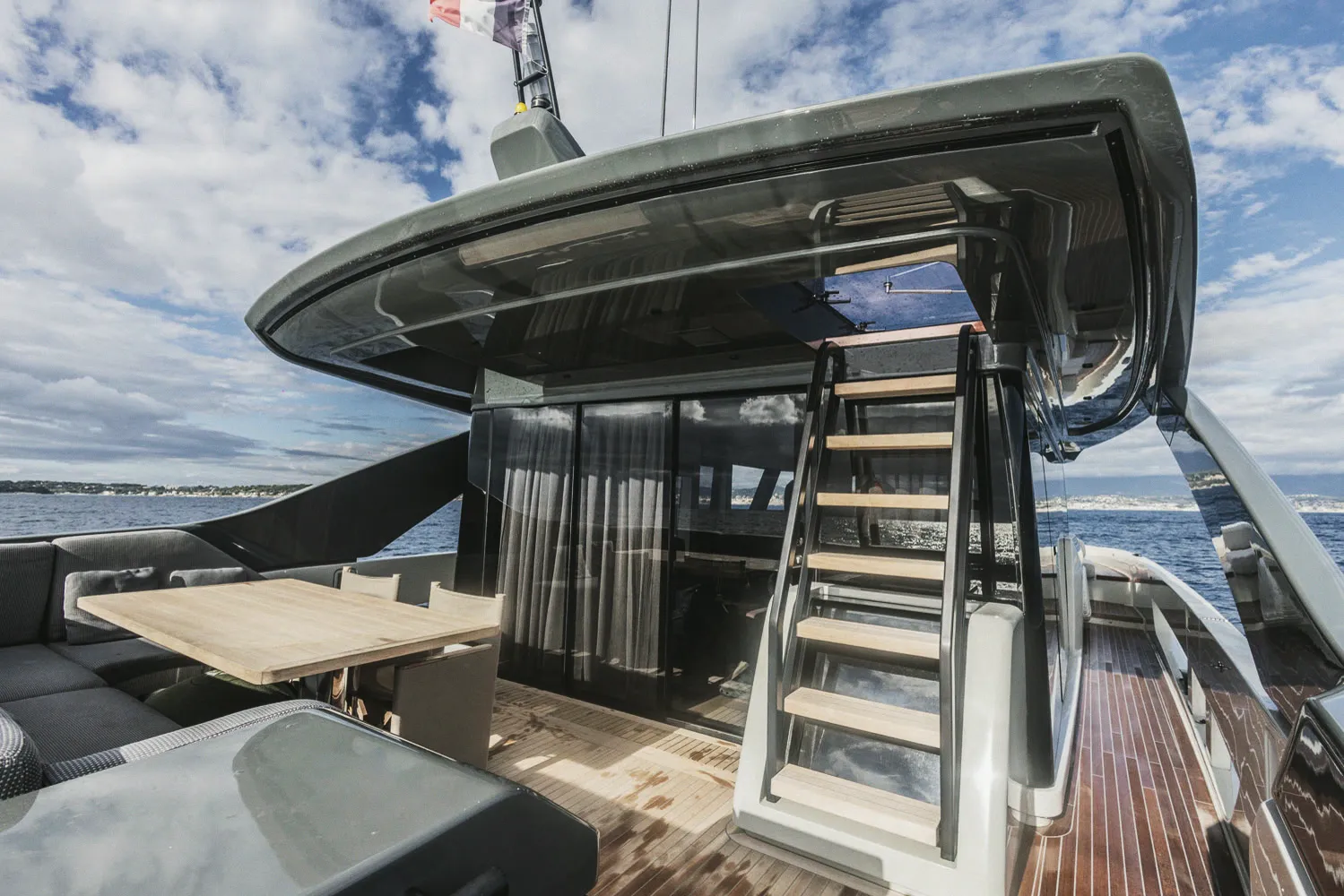 Le cockpit et l'escalier menant au pont supérieur, table et banquette en teck.