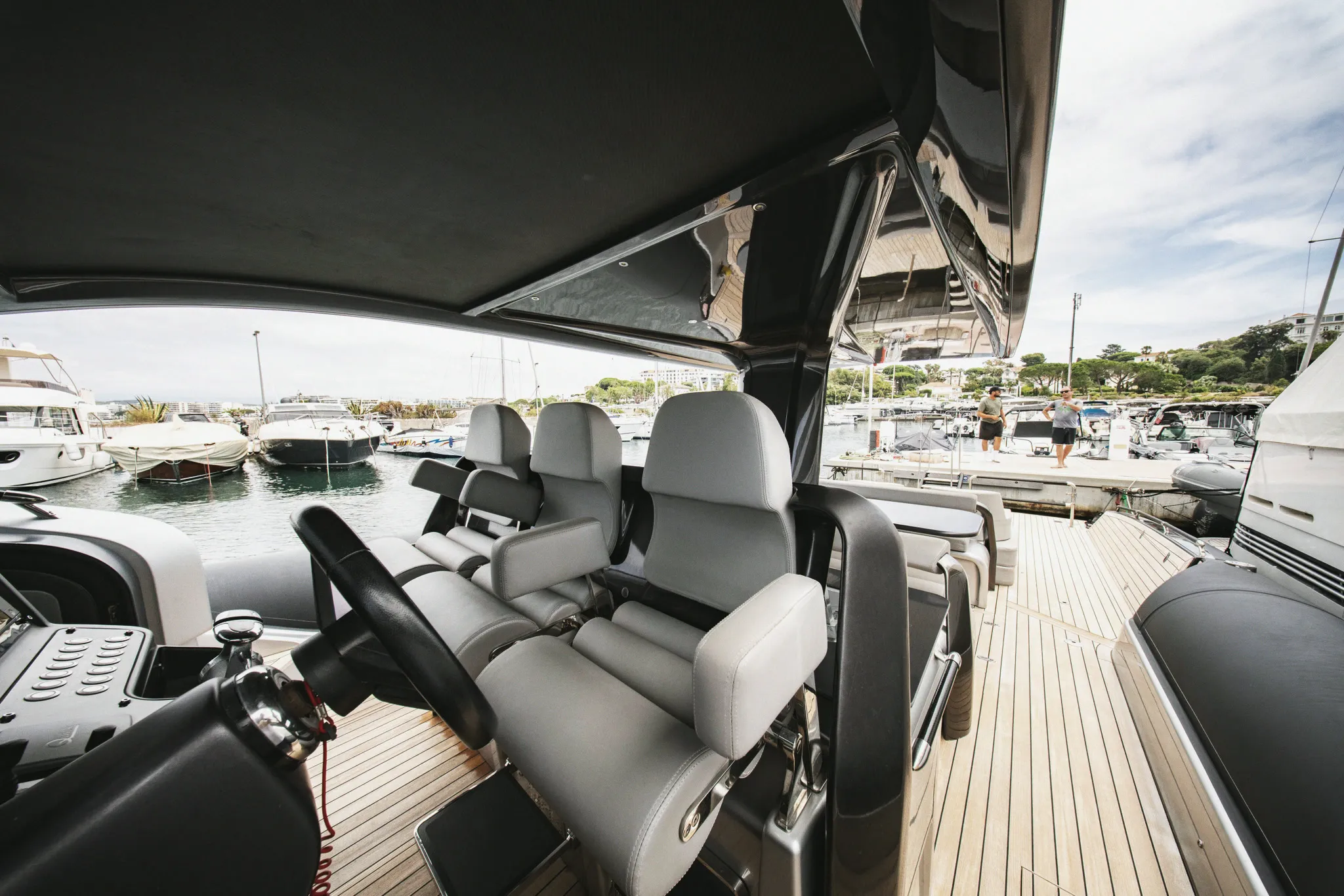 Le poste de pilotage : sièges pilotes, barre et console, ouvert sur le port.