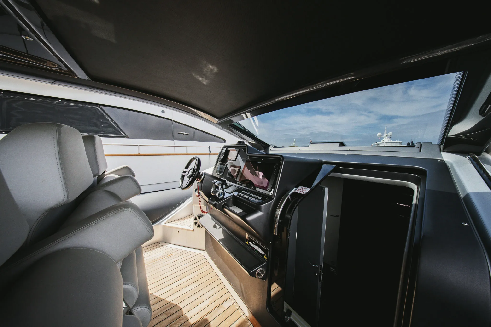Le poste de pilotage vu de l'intérieur : sièges, console et ouverture sur le pont.