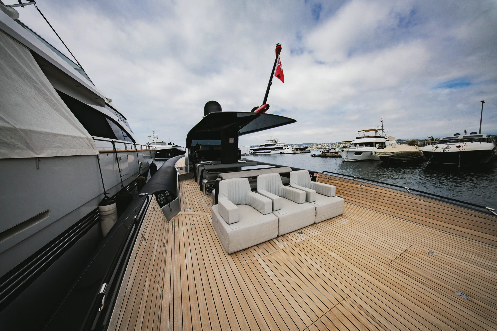 Trois assises alignées sur le passavant tribord, pavillon et port derrière.