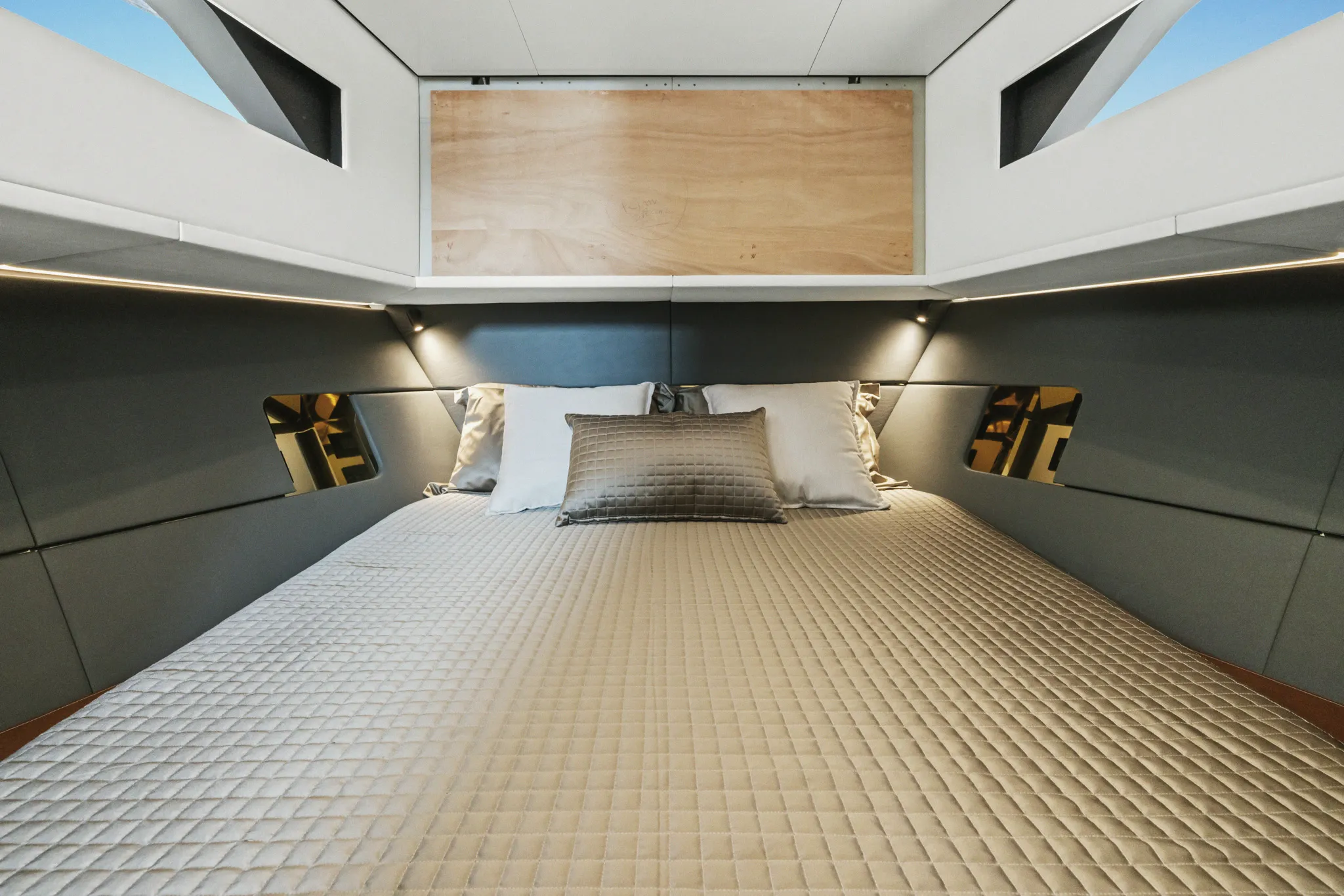 Cabine d'un yacht Forte : couchage double entre deux hublots de coque.