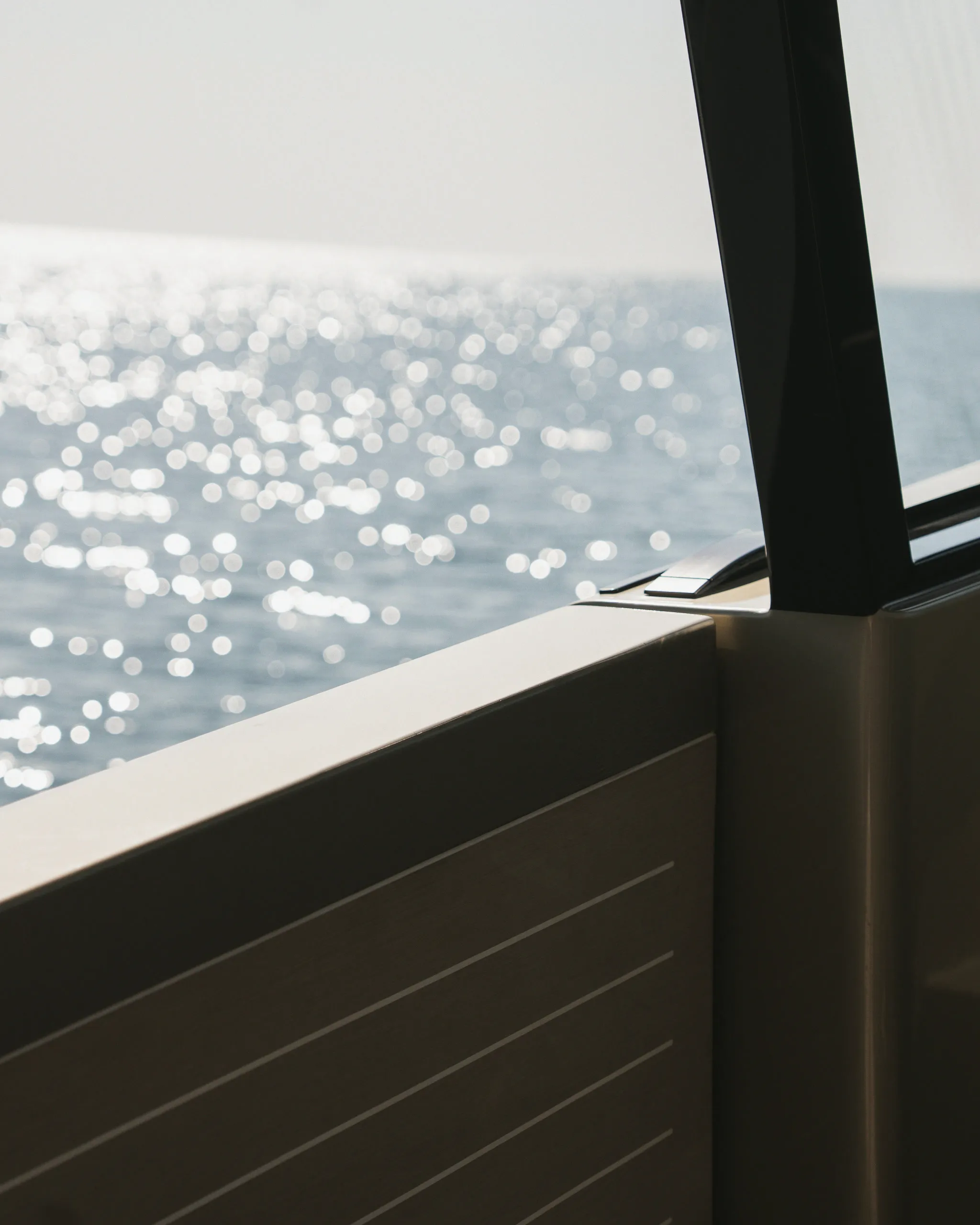 Vue depuis le pont d'un yacht sur la mer au large, reflets de soleil sur l'eau.