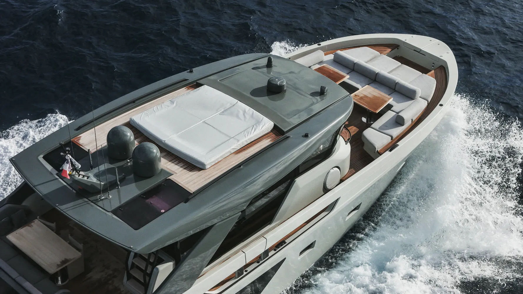 Un yacht en marche vu à la verticale, sillage ouvert sur une mer libre.