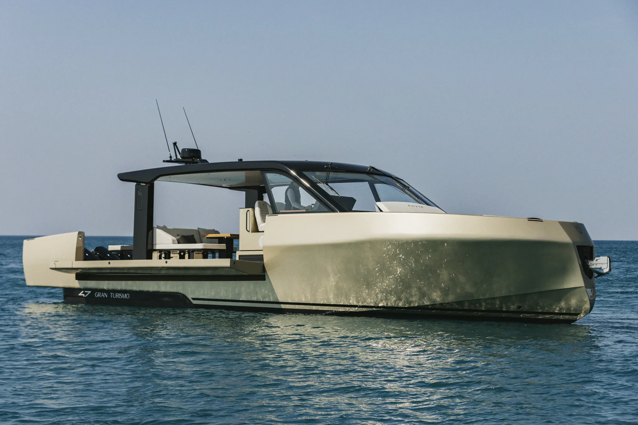 Yacht à moteur vu de flanc tribord, arrêté sur une mer calme, plage arrière ouverte.